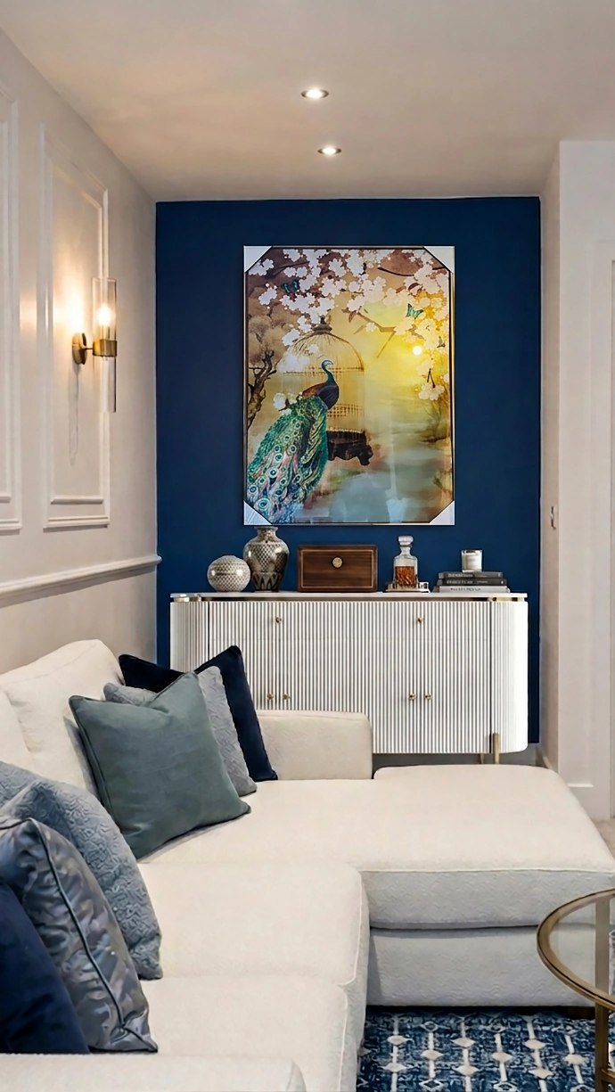 Bespoke living room interior design in Leeds, UK featuring elegant white sofa styling, blue accent wall, curated artwork, and refined contemporary decor by House of Ahana.