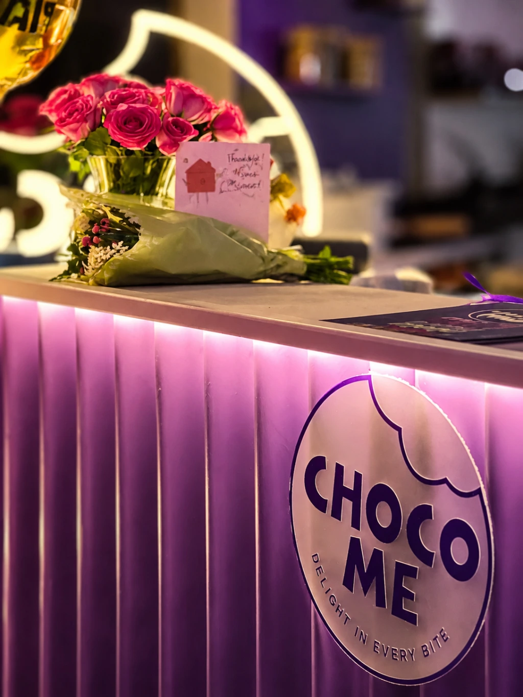 The Choco Me interior uses rich purples, warm lighting, and complementary colours to strengthen brand identity and create an indulgent atmosphere. Purple brand colour, warm lighting, and soft accent tones used throughout the Choco Me dessert shop to create a cohesive and inviting customer experience.