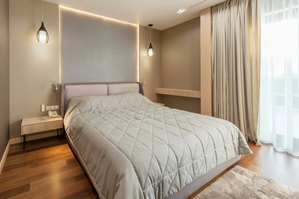 Luxury residential bedroom interior design in UK with modern lighting and warm neutral tones.