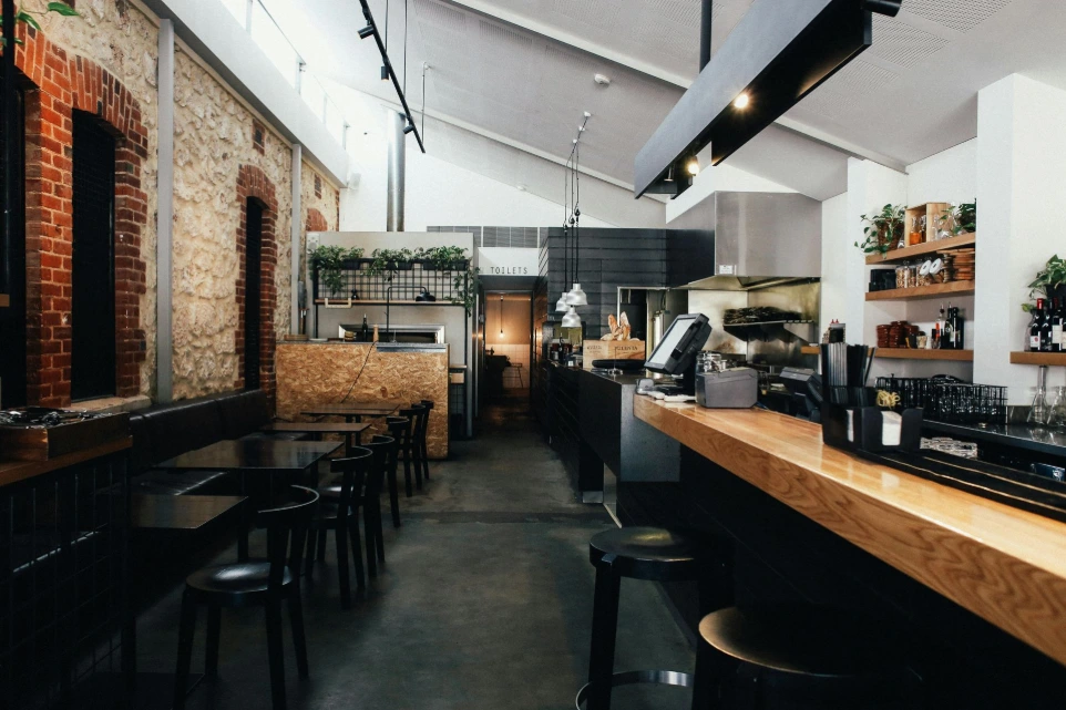Modern bar interior with industrial design, wooden counter seating and ambient lighting in a London UK setting