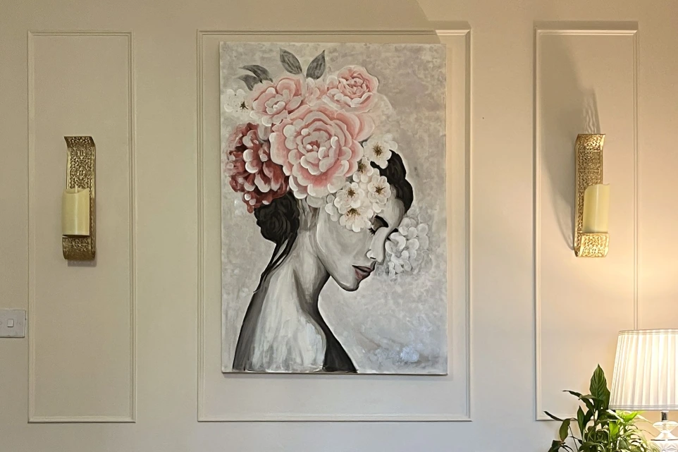 Bespoke floral woman portrait painting with soft pink tones, hand-painted artwork styled in a luxury interior setting in the UK